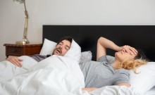 Homme qui ronfle au lit à côté de sa femme