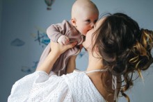 Une jeune maman qui porte son bébé